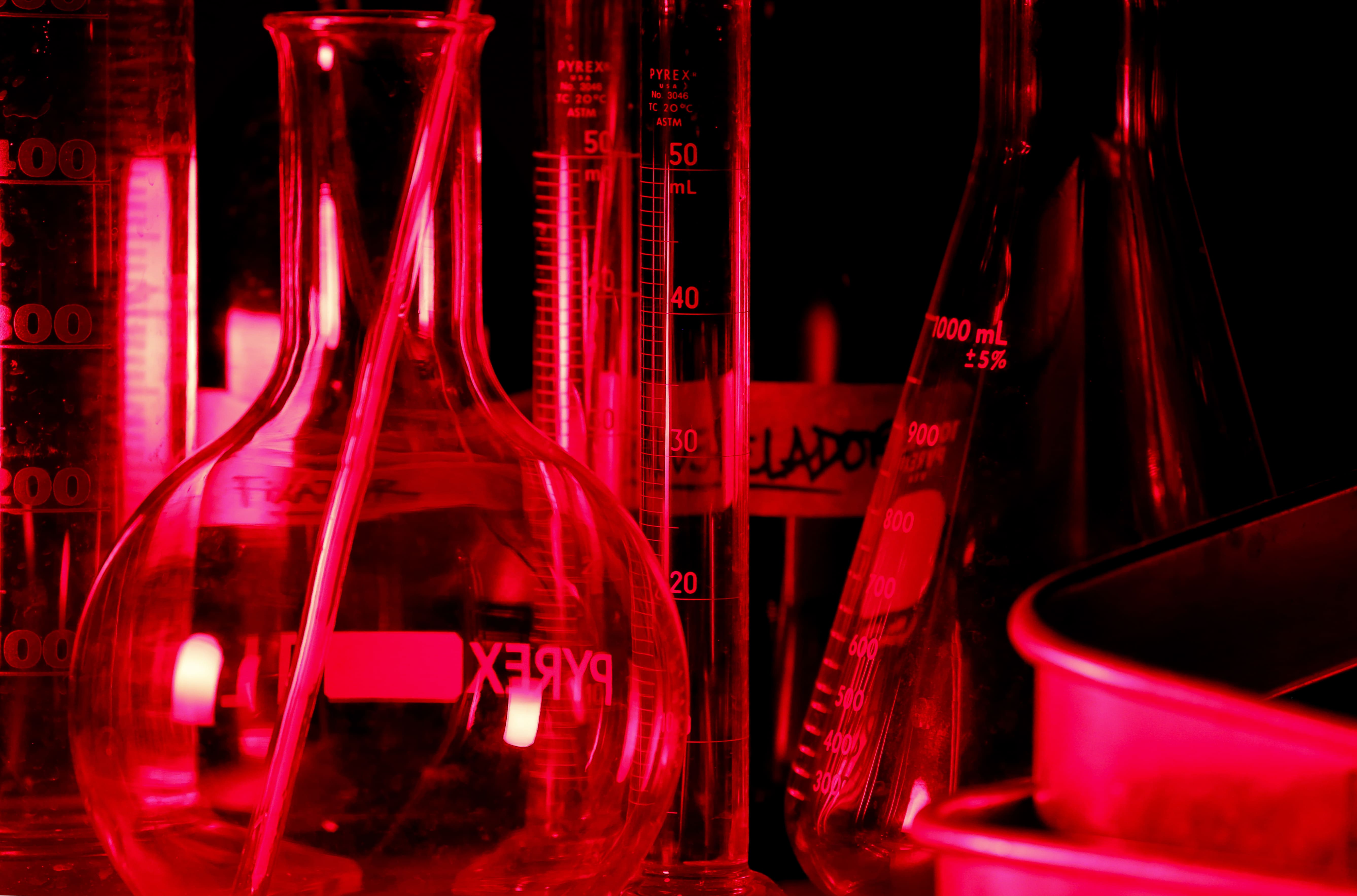 Vidraria Pyrex do laboratório fotográfico sob luz vermelha profunda